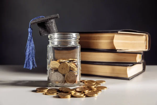 Ahorro para el concepto de educación. Monedas en tarro con monedas y libros —  Fotos de Stock