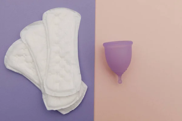 Menstrual cup and sanitary pads on a colorful background. Top view. Concept of womens hygiene and health care — Foto Stock