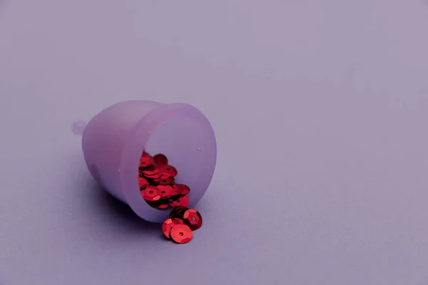 Taza menstrual higiénica con lentejuelas rojas brillantes de cerca —  Fotos de Stock