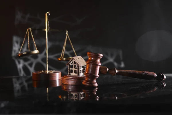 Concept of suing for property. Wooden gavel with house close-up