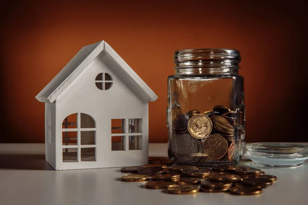 Modelo de casa y frasco de vidrio con monedas, bienes raíces y dinero concepto de ahorro — Foto de Stock