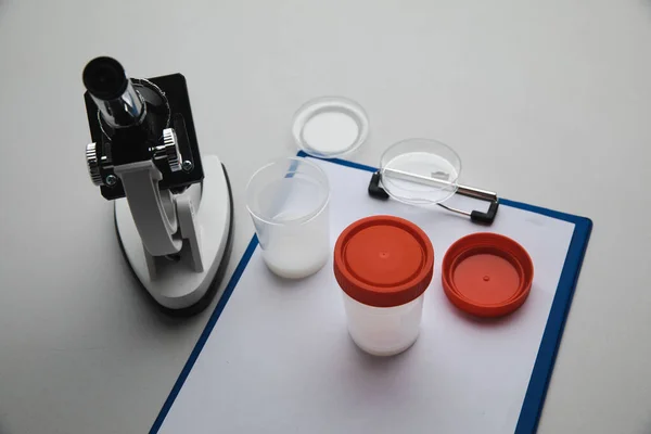 Пластикова банка зі спермою та мікроскопом в лабораторії. Концепція вагітності, здорового догляду та аналізу — стокове фото