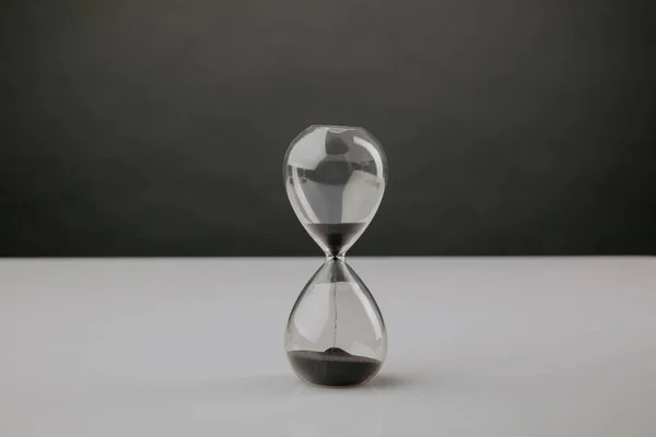 Сучасний пісочний годинник на столі з темним фоном, концепція дедлайну — стокове фото