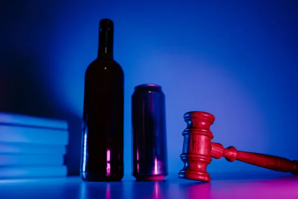 Alkohol- és bűnügyi fogalom. Palack whiskyvel, korsó sörrel és kalapáccsal neonfényben. — Stock Fotó