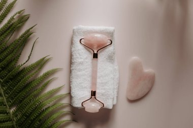 Pembe gua sha ve kuvars yüz masajı silindiri. Güzellik ve bencillik kavramı