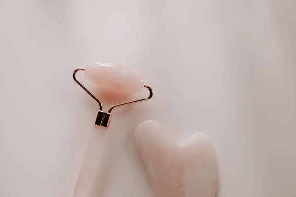 Rodillo de masaje facial rosa gua sha y cuarzo de cerca —  Fotos de Stock