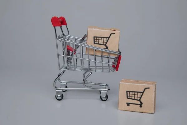 Winkelen en levering concept. Mini winkelwagen met verzendpapier dozen. — Stockfoto