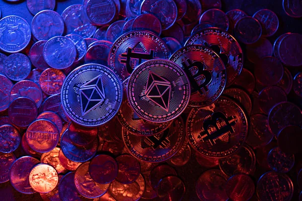ABD Doları ve Euro bozukluklarının üstüne yığılmış Kriptopara Bitcoin paraları. Kripto dünyada popülerlik ve kabullenme artışı