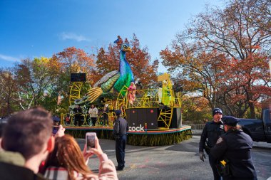 Manhattan, USA - 24. November 2021: Peacock Parade float in NYC during Thanksgiving Parade in Manhattan. Celebrating Thanksgiving. People taking pictures of Macy's Parade