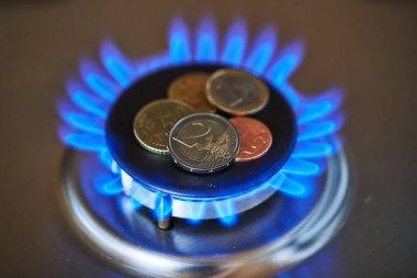 Euro coins on top of gas hob. Gas stove with money. Expensive natural gas. Prices for heating and cooking rising