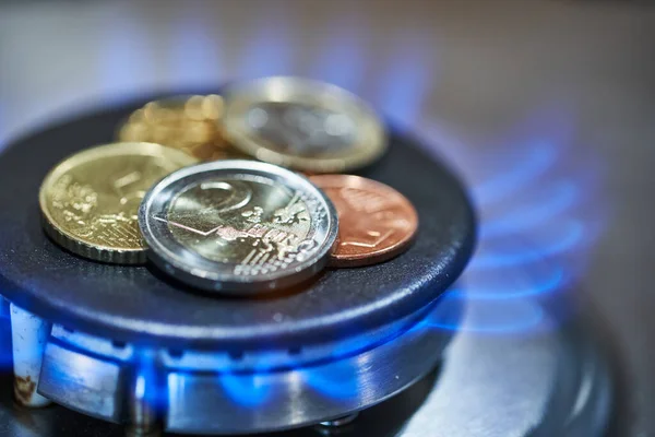 Ocağın üzerinde parlak Euro sikkeleri. Gaz yanıyor. Benzin fiyatları kavramı