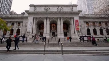 Manhattan, New York, ABD - 12 Kasım. 2019: Manhattan Halk Kütüphanesi Girişi. Bryant Park 'ın yakınlarındaki tarihi ve turistik bir yer. Kütüphaneye yürüyen ve giren insanlar