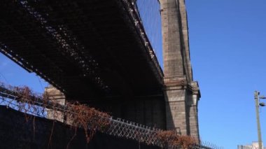 Brooklyn, New York, ABD - 26 Ekim. 2019: Brooklyn Köprüsü 'nün altından geçen sütun, New York Brooklyn Köprüsü Parkı' nda sonbahar manzarası