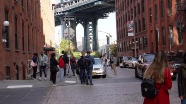 Brooklyn, New York, ABD - 26 Ekim. 2019: Brooklyn 'de Manhattan Köprüsü altında kalabalık Dumbo, turistler fotoğraf çekiyor ve poz veriyor