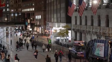 Manhattan, New York, ABD - 6 Kasım. 2019: NYSE Borsası önünde geceleyin yürüyen insanlar. Amerika Birleşik Devletleri Bayrağı Pazar yerinin önünde dalgalanıyor