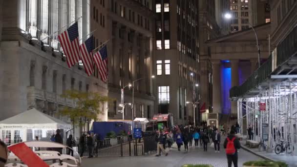 マンハッタン ニューヨーク 11月6日 2019 金融街で働く人々 仕事の後の夕方にニューヨーク証券取引所の前を歩く群衆 市場でのアメリカ国旗 — ストック動画