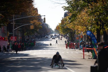 Brooklyn, New York, ABD - 3 Kasım. 2019: NYC Maratonu, caddenin aşağısındaki koşucuların önünde tekerlekli sandalye sporcusu.