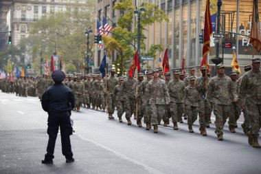 Manhattan, New York, ABD - 11 Kasım. 2019: 77 Amerikan Ordusu askerleri New York 'ta Beşinci Cadde' ye yürüyorlar. Amerikan askeri piyadeleri bayraklar ve kamuflaj üniformaları taşıyor.