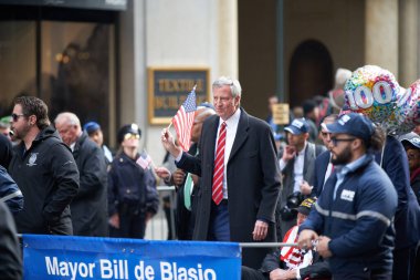 Manhattan, New York, ABD - 11 Kasım. 2019: Başkan Bill de Blasio 'nun elinde ABD bayrağı var. New York Belediye Başkanı Beşinci Cadde 'de Gaziler Günü Geçidi' nde yürüyor.