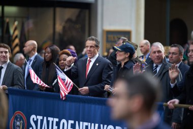 Manhattan, New York, ABD - 11 Kasım. 2019: New York Eyaleti Valisi Andrew Cuomo, New York 'taki Gaziler Günü Geçidi sırasında elinde Amerikan bayrağı ile Beşinci Cadde' de yürüyor.