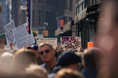 Manhattan, New York, ABD - 11 Kasım. 2019: NYC 'de Gaziler Günü' nde protestocuları ezmek, insanların kafalarının üstündeki işaretler.