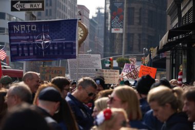 Manhattan, New York, ABD - 11 Kasım. 2019: Madison Square Park 'taki NYC Gaziler Günü Geçidi' nden önce kalabalık. Donald Trump karşıtı ve NATO bayrağı taşıyan insanlar .
