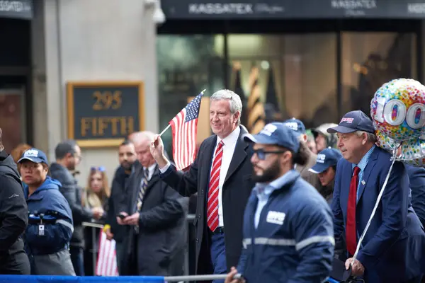Manhattan, New York, ABD - 11 Kasım. 2019: Başkan Bill de Blasio 'nun elinde ABD bayrağı var. New York Belediye Başkanı Beşinci Cadde 'de Gaziler Günü Geçidi' nde yürüyor.