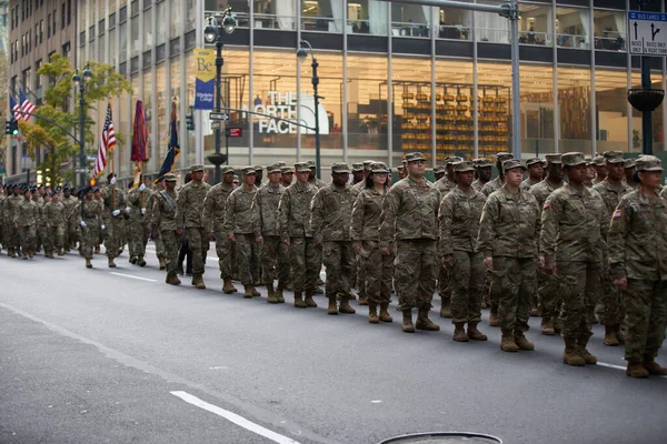 Manhattan, New York, ABD - 11 Kasım. 2019: 77 Amerikan Ordusu askerleri New York 'ta Beşinci Cadde' ye yürüyorlar. Amerikan askeri piyadeleri bayraklar ve kamuflaj üniformaları taşıyor.