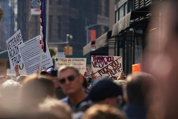 Manhattan, New York, ABD - 11 Kasım. 2019: NYC 'de Gaziler Günü' nde protestocuları ezmek, insanların kafalarının üstündeki işaretler.
