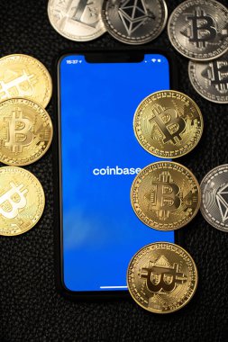 Bolzano, İtalya - 10 Nisan. 2021: Akıllı telefondaki bozuk para uygulaması bitcoin ve deri arka plandaki ethereum paraların yanında