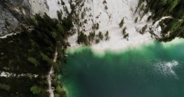 Alp Gölü 'nün yukarıdan görünen manzarası, Havadan manzara. Güney Tyrol 'daki Braies Gölü, tatil için popüler turizm beldesi ve Alpler' in vahşi doğasında gezinti. Beyaz Sahilde Karanlık Suda Kayboluyor