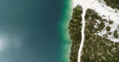 Aerial Beach, güzel göldeki beyaz kumlu plajlar. 4K 'da yukarıdan insansız hava aracı atışı. Deniz kıyısındaki yol. Dolomitlerdeki Lago di Braies. Alplerdeki doğa, açık hava maceraları ve vahşi doğada dinlenme.