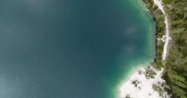 Aerial Gölü, Alpine Gölü ve Shore 'un üst tarafı. Temiz su üzerinde beyaz kum bulunan Aerial Plajı. Dolomitlerdeki Prag Gölü, Güney Tyrol. 4K İHA atışı. Cennet Sahili