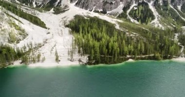 Dolomitlerdeki Aerial Lake Braies, Alpler. Göl yukarıdan görünüyor, Doğa 'daki Maceralar. İtalya 'daki Hava Dağı manzarası. 4K 'da beyaz plajlar ve çam ağaçlarıyla çevrili Güzel Su