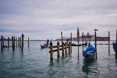Piazza San Marco 'dan Venedik' teki Lagoon 'a. Tahta direğe bağlanmış bir gondol.