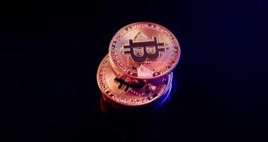 Siyah yüzey üzerinde dönen altın Bitcoin paralar. Altın ışıkla aydınlatılmış. Kripto para birimi sikkeleri gelecekteki ekonomiler konsepti