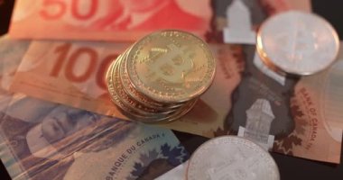 Toronto, Kanada - 19 Ekim. 2021: Kanada Doları 'nın üstüne altın ve gümüş Bitcoin. Kanada konseptinde kripto para ticareti