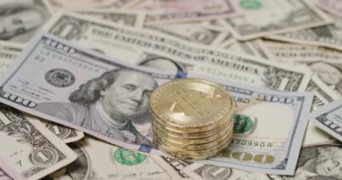 ABD 'den gelen 100 dolarlık banknotların üzerine Bitcoin paraları yığılmış. Kripto para birimi kavramı ticareti