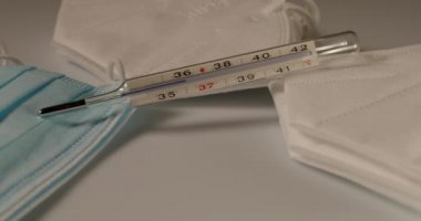 Yüz maskesi üzerinde ateş ölçer, cerrahi ve N95 yüz maskeleri. Koruma ve tanı aracı