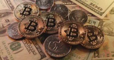 Amerika 'dan gelen yarım dolarlık paraların üzerine parlayan Bitcoin paralar. Şifreli Bitcoin 'in USD para birimi konseptiyle ticareti