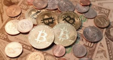 Altın parlayan Bitcoin paralar Amerikan Doları banknotları ve paralarının üstünde. Değişken kripto pazarına yatırım