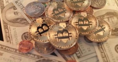 Dolar banknotları ve paraların üzerinde altın parlayan Bitcoin sikkeler, uluslararası pazarda kripto paralar ve NFT ticareti