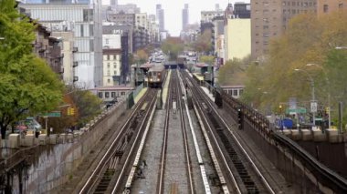 Bir metro treni, kırmızı hat, Manhattan şehir merkezine giden metro istasyonundan kalkıyor. Hava görünümü