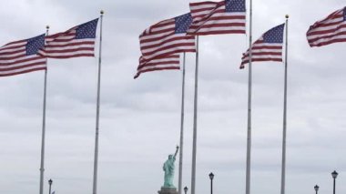 Rüzgarda dalgalanan Amerikan bayrakları. Arka planda Özgürlük Anıtı. Özgürlük ve özgürlük