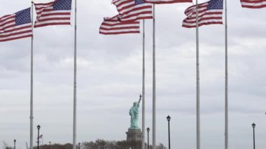 Amerika 'da özgürlük ve özgürlük. Amerikan bayrakları, arka planda özgürlük heykeli. Amerika Birleşik Devletleri bayrakları rüzgarda dalgalanıyor