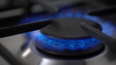Yanan gaz ocağı, gaz ocağı, mutfakta hob. Yavaş çekim gaz ocağı açılıyor ve yanıyor