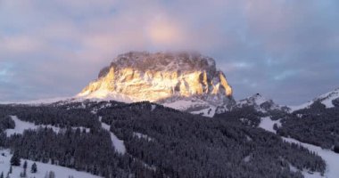 Kışın dağ manzarası, Val Gardena 'daki Sassolungo Dağı' nda güzel bir gün batımı. Kar yağışlı sabahın erken saatlerinde kayak merkezinde. Dağların ve ormanın havadan manzarası. Kayak pistleri ve asansörler