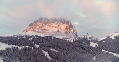 Kışın gün doğumu manzarası, karla kaplı dağlar. Val Gardena 'daki Sassolungo' nun Aerial Mountain manzarası. Turuncu ve Mavi, Güneş 'teki Dağ ve Gölge Ormanı' nın etrafındaki sabah erken saatlerde. İHA