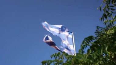 Güçlü rüzgârda dalgalanan Yunan Bayrağı. Parçalanmış Yunanistan Bayrağı