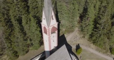 Ormandaki kilisenin yüksek açılı manzarası. Hava görüntüsü. Val Gardena 'daki kilise kulesi.